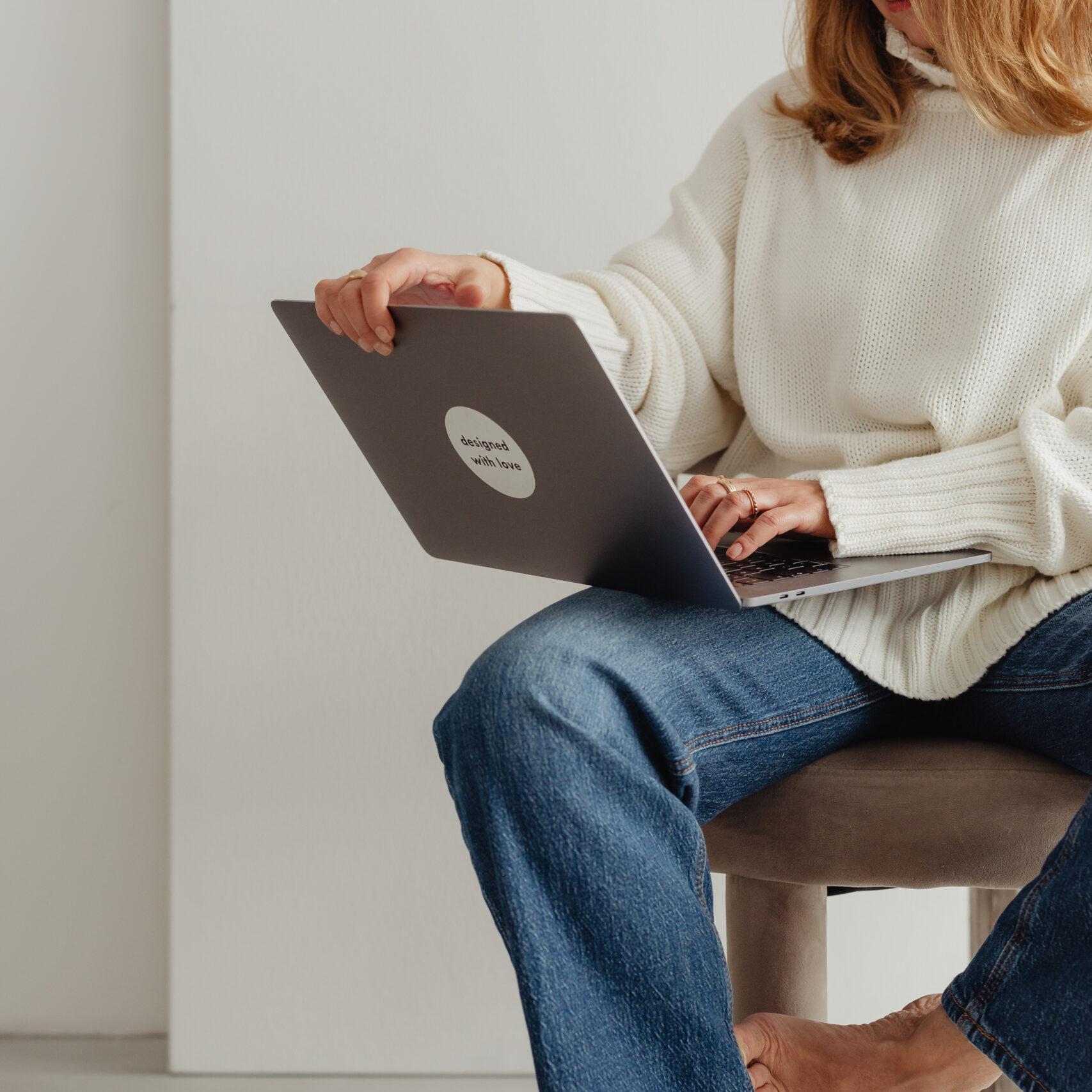 kaboompics woman in white sweater gold rings jewelry jeans laptop work 29449 (1)